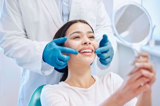 woman at a consultation smiling into a mirrror